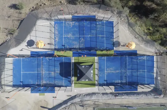 Vista aérea de canchas de padel con césped artificial azul